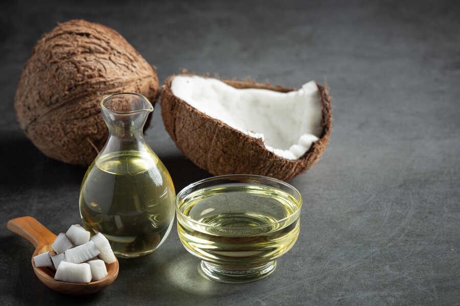 Coconut products on a dark background with focus on coconut oil and meat